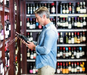 Man browsing wine selection at a wine store.
